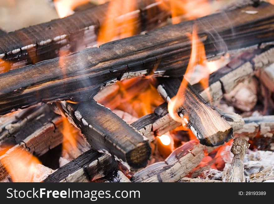 Camping bonfire with flame and firewood fragment close-up view. Camping bonfire with flame and firewood fragment close-up view