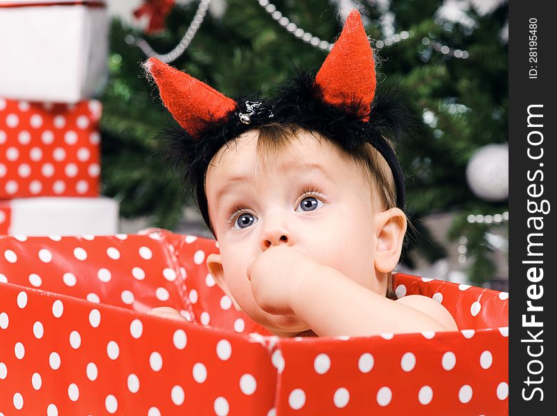 Christmas baby girl with horn in a studio. Christmas time