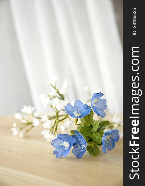Blue and white artificial flowers put on the window side