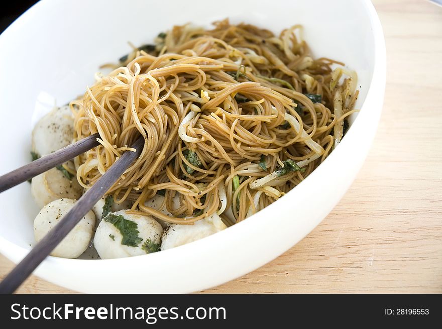 Chopsticks on asian noodle in white bowl