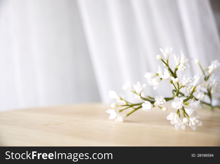 White artificial flowers put on table window side