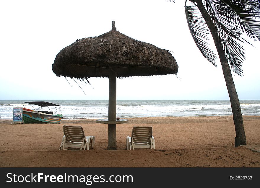 Deckchair on a tropical beach with sky and white sand