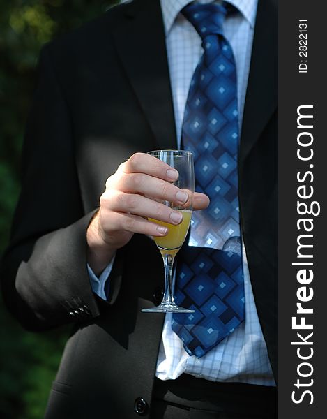 Guy in a smart suit drinking a celebration toast