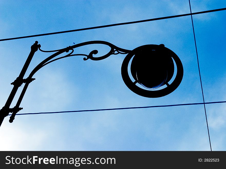 Street lamp silhouette against blue sky