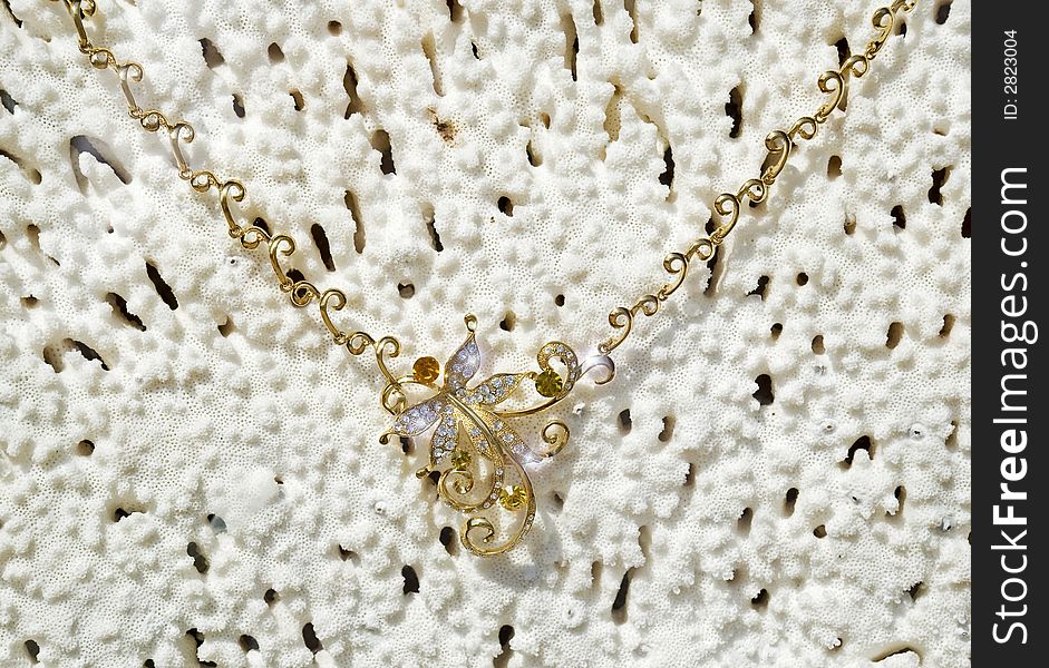 Gold necklace on a background from a sea coral