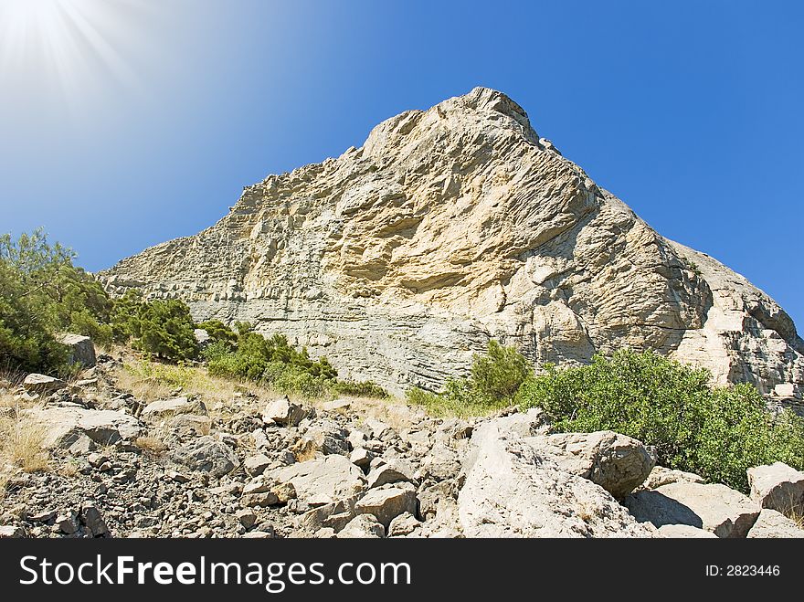 Fragment of the big rock on a background of the sated dark blue sky. Fragment of the big rock on a background of the sated dark blue sky