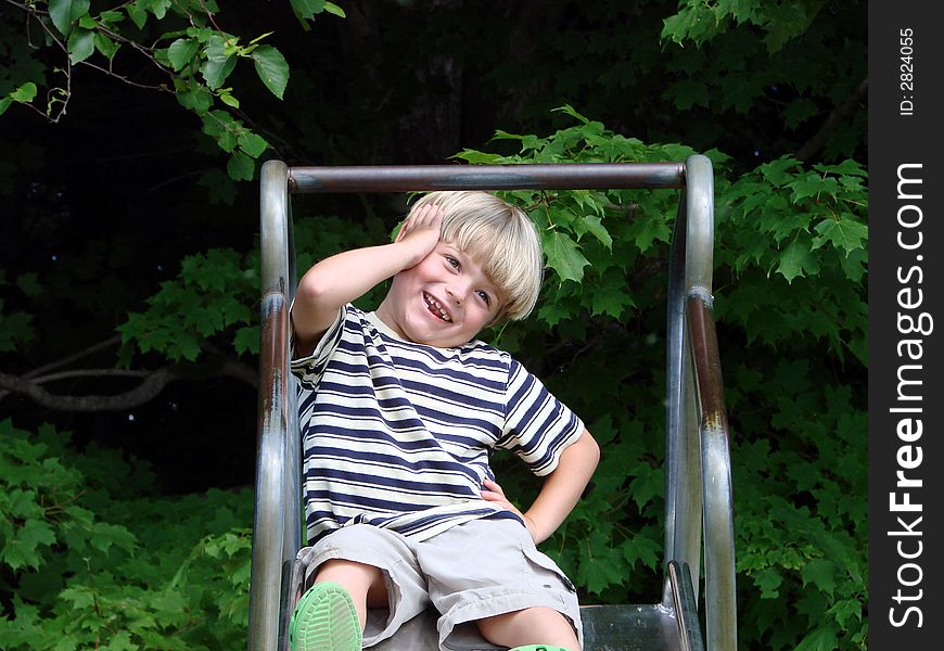 Young boy playing on slide at playground