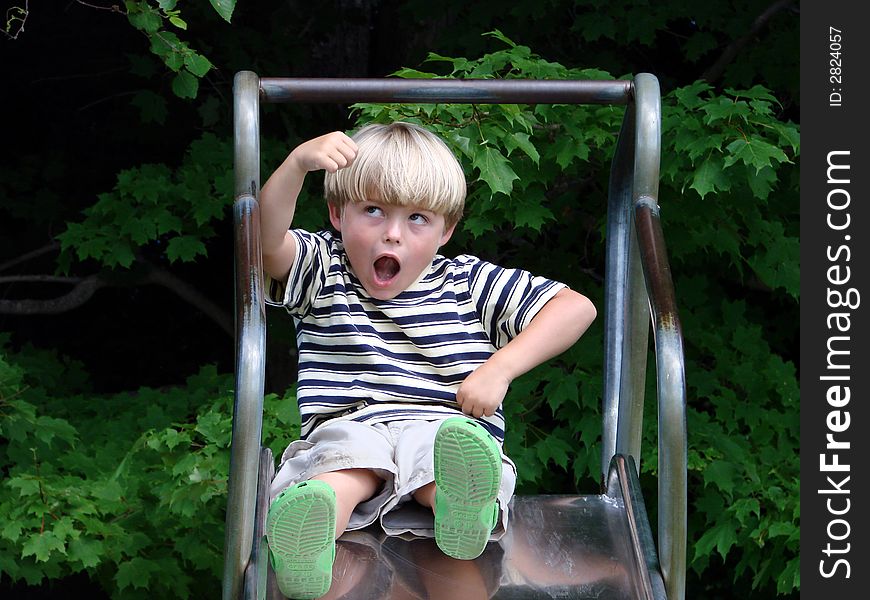 Young boy playing on slide at playground