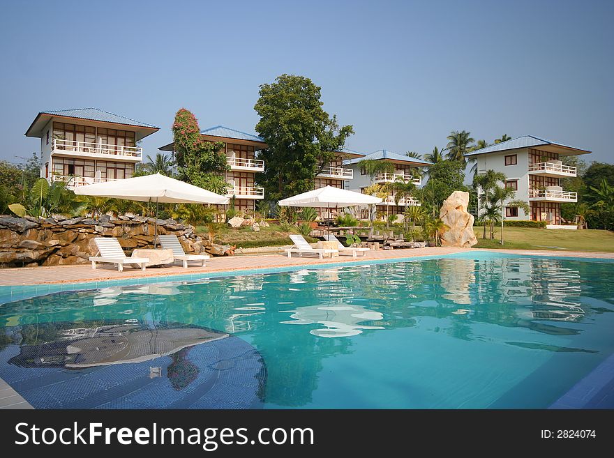 Swimming Pool With Bungalows In The Background