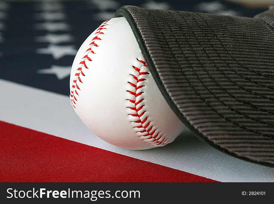 A hat and baseball on top of an American flag. A hat and baseball on top of an American flag.