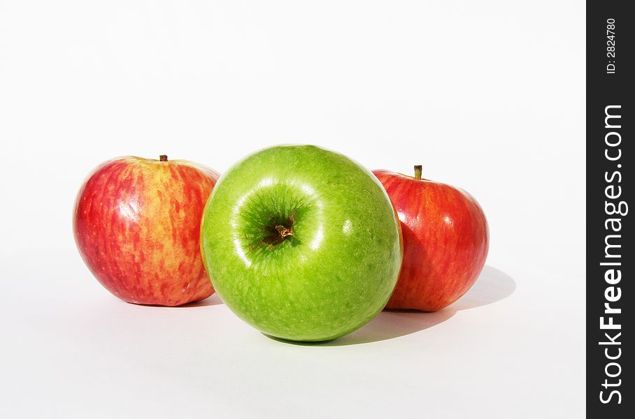 One green and two red apples on a white background. One green and two red apples on a white background.