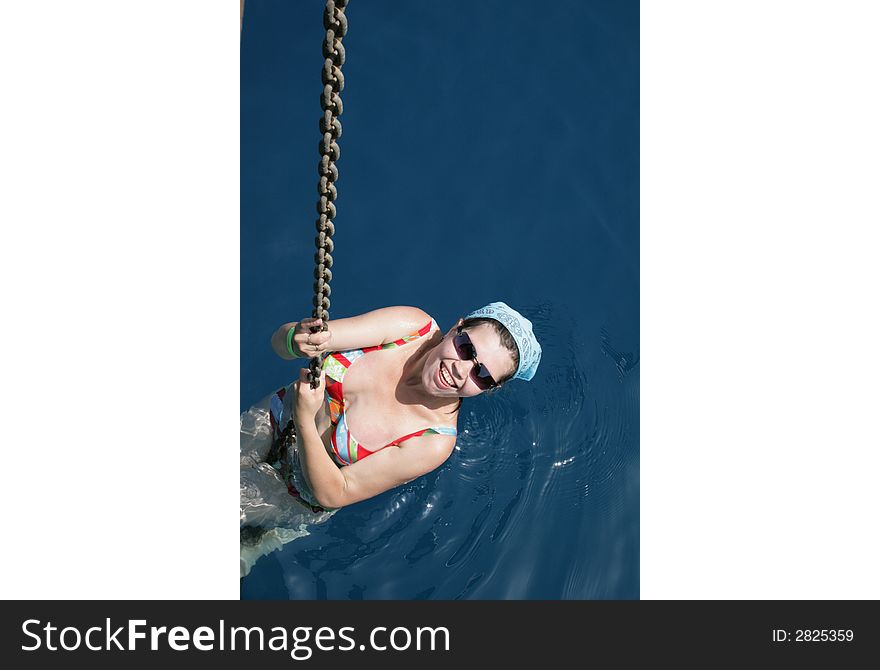 The girl bathing in the sea, has hung on an anchor circuit of a yacht. The girl bathing in the sea, has hung on an anchor circuit of a yacht.