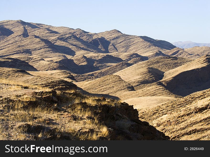 Desert landscape in Africa Namibia, golden rocks, clear blue sky