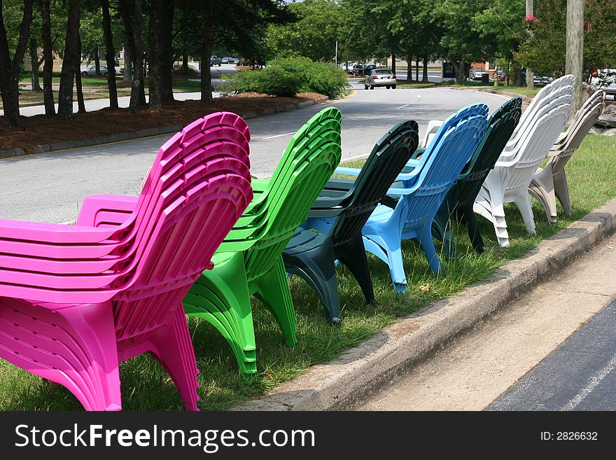 Many colored plastic chairs for sale in front of store. Many colored plastic chairs for sale in front of store