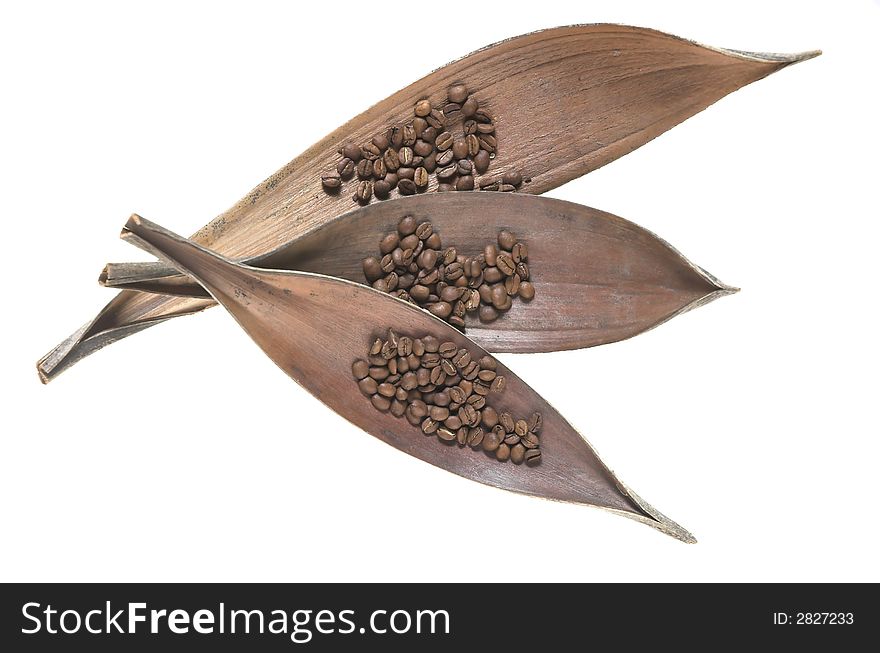 Coffee laying on dry leaves on a white background. Coffee laying on dry leaves on a white background