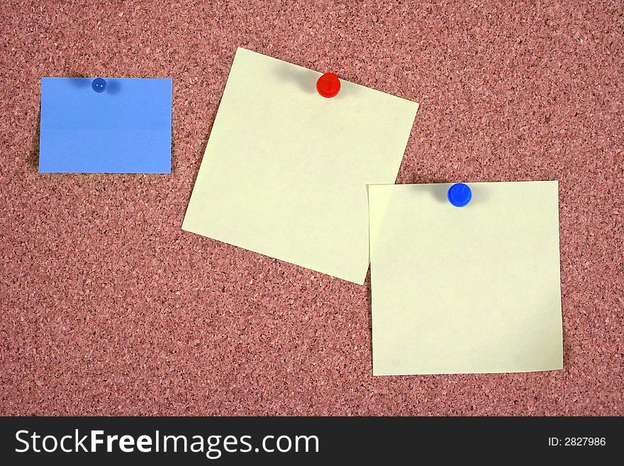 Blue and yellow papers attached to a corkboard. Blue and yellow papers attached to a corkboard.