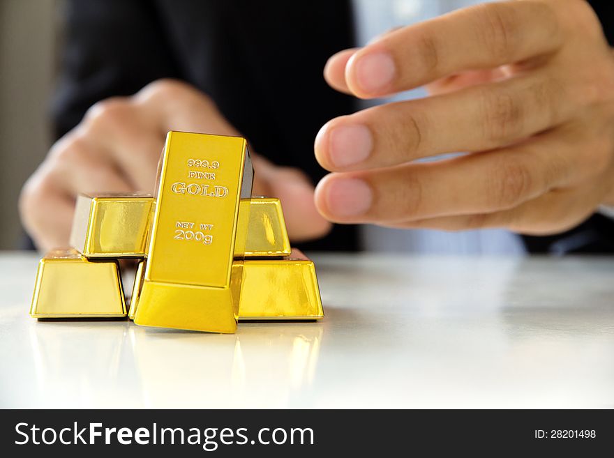 Image of hand holding gold bars