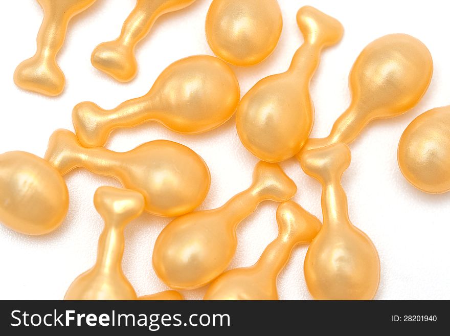 Yellow fish oil capsules on a white background