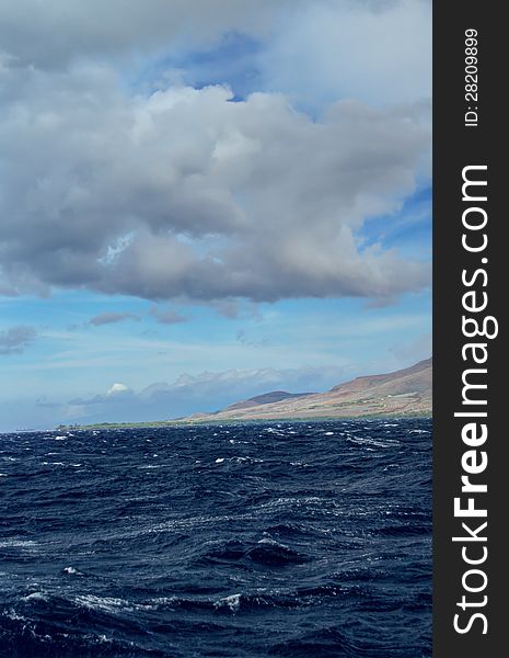 Stormy clouds with rough seas. Maui mountains in the background. Stormy clouds with rough seas. Maui mountains in the background