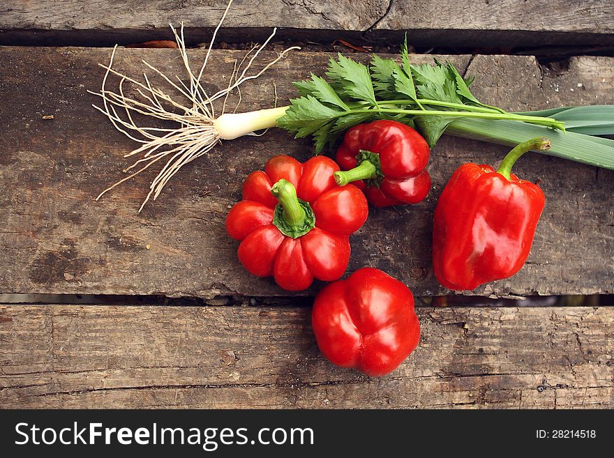 Red pepper and green onions on a wooden table. Red pepper and green onions on a wooden table