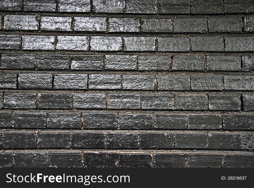 Black painted brick wall background with light reflections. Black painted brick wall background with light reflections