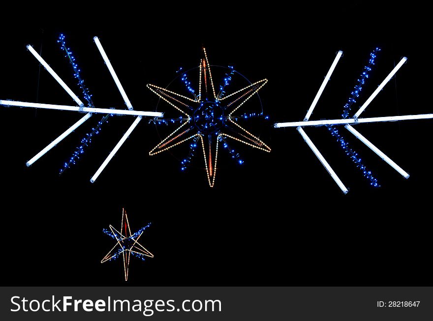 Christmas decoration with star shaped yellow and blue lights isolated on black