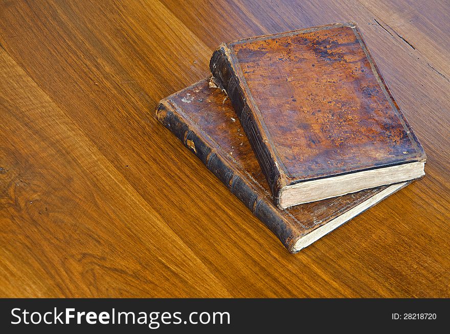 Old books with brown leather covers on a wooden surface. Old books with brown leather covers on a wooden surface