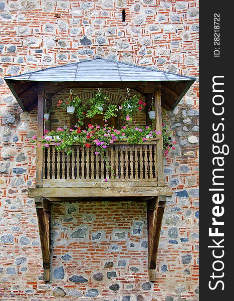 Wooden balcony decorated with pink and red flowers