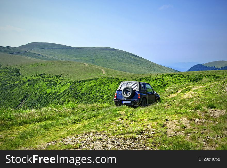 Travelling by car in a mountain pasture