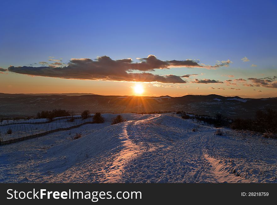 Beautiful winter sunset landscape on a hill