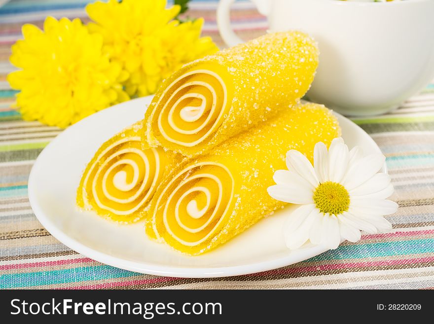 Yellow candy fruit on a plate, closeup