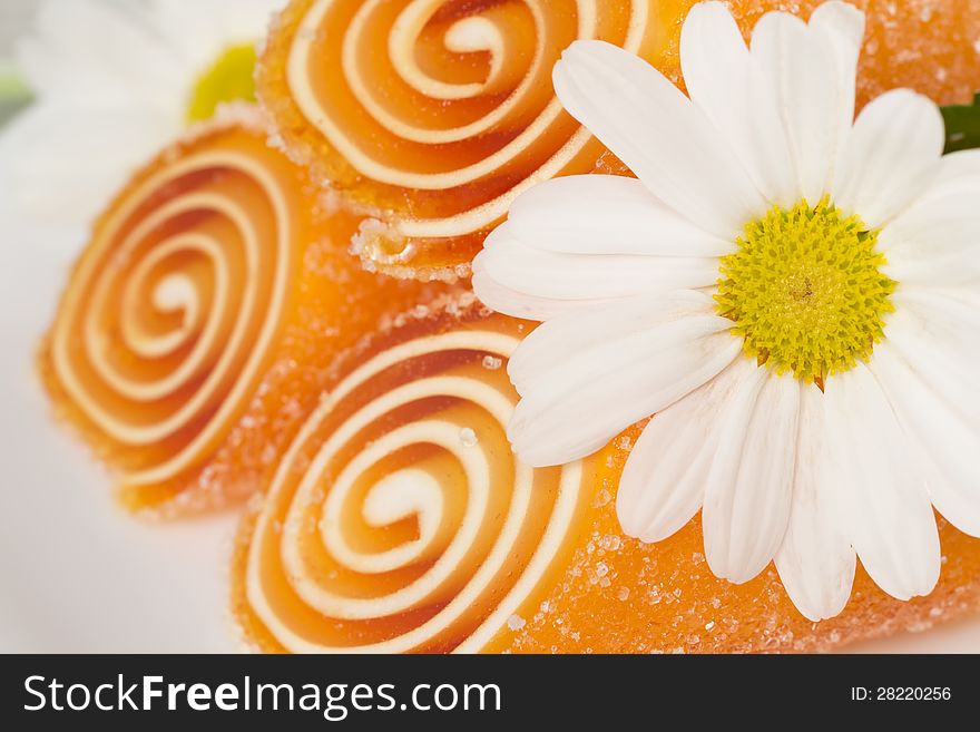 Orange candy fruit on a plate background, closeup