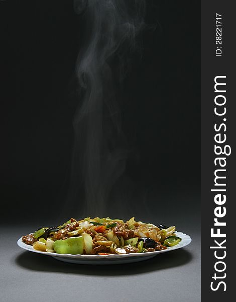 Beef with vegetables and bamboo shoots in plate on a neutral background