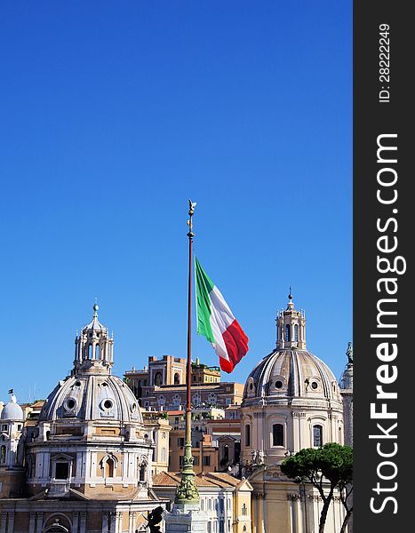 Beautiful Santa Maria di Loreto church and an Italian flag in Rom, Italy. Beautiful Santa Maria di Loreto church and an Italian flag in Rom, Italy