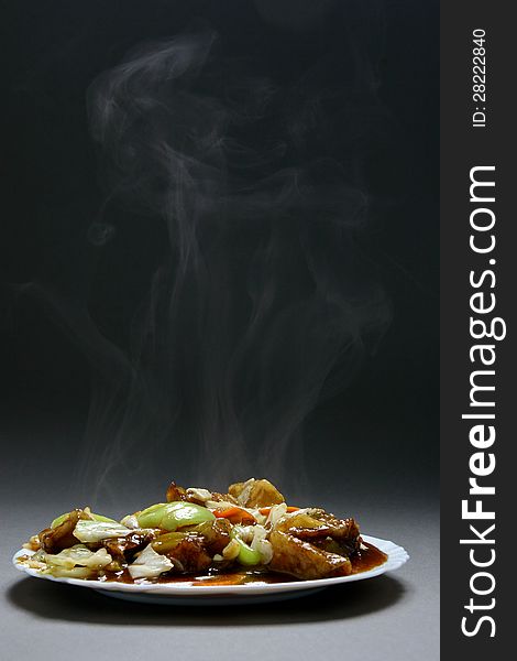 Beef with vegetables and bamboo shoots in plate on a neutral background