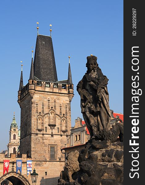 View of ancient sculpture on background with gothic towers in Prague. View of ancient sculpture on background with gothic towers in Prague