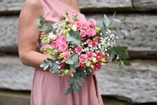 Free A Young Girl In A Pink Dress Holds A Bouquet Of Roses And White Flowers Stock Image - 282265031