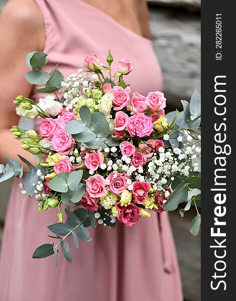 A Young Girl In A Pink Dress Holds A Bouquet Of Roses And White Flowers