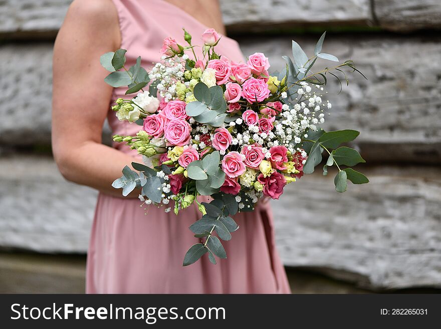 A Young Girl In A Pink Dress Holds A Bouquet Of Roses And White Flowers