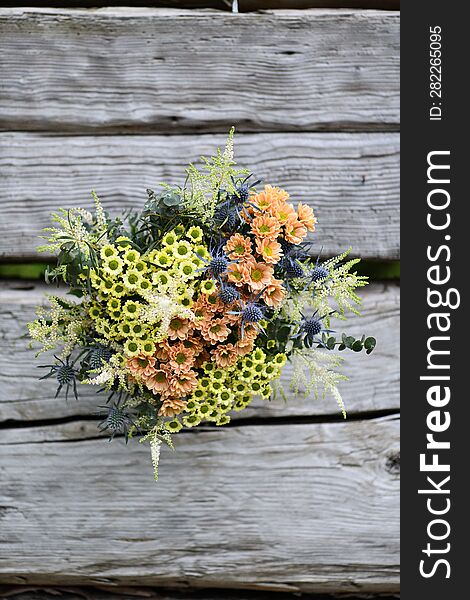 A Large Bouquet Of Yellow And Orange Meadow Flowers On A Wooden Table