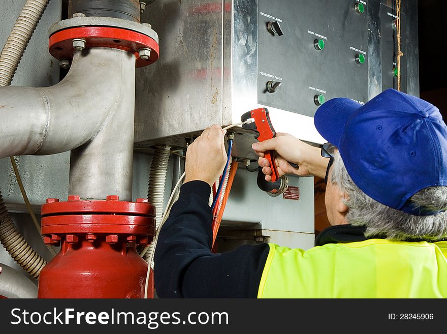 Electrician while working with cables and wires of electronic components