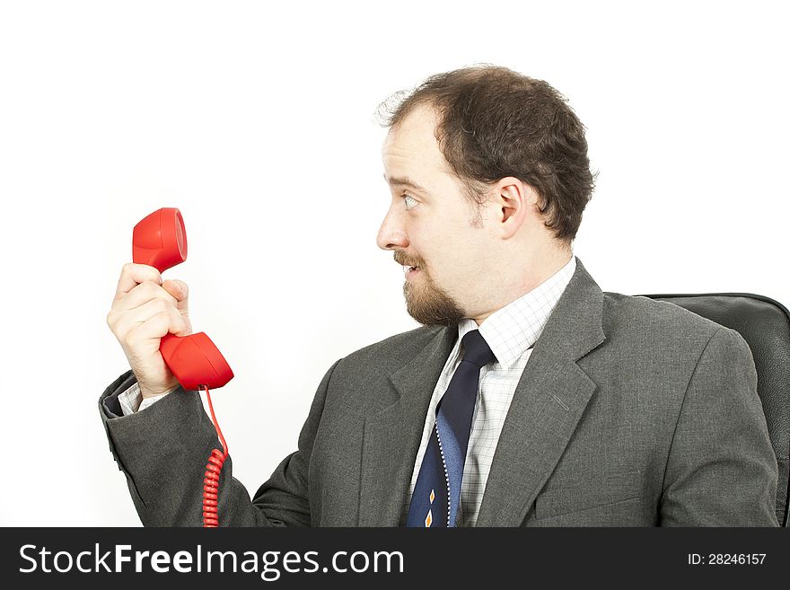 Businessman with red phone looks surprised. Businessman with red phone looks surprised