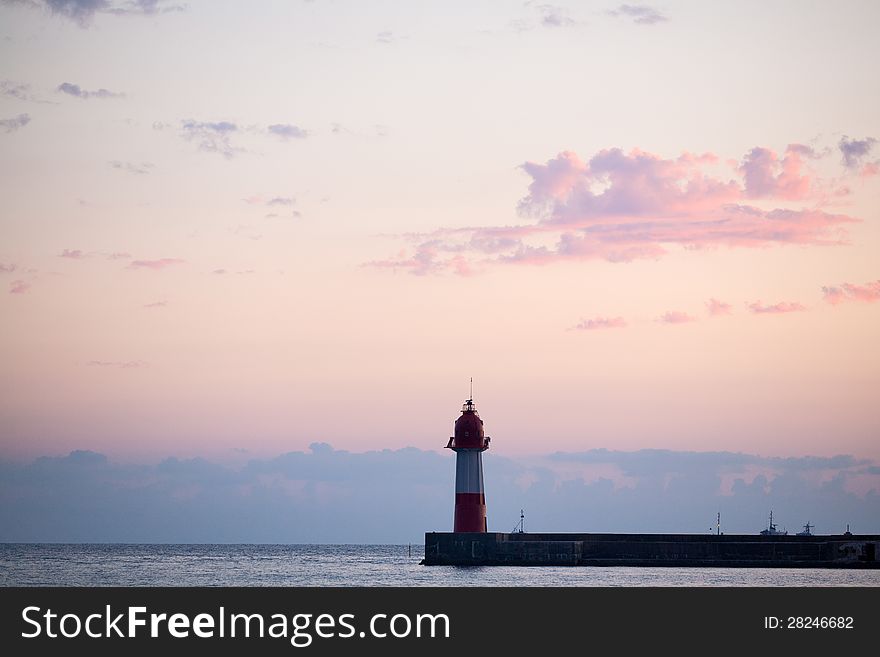 Lighthouse near sea at sunset