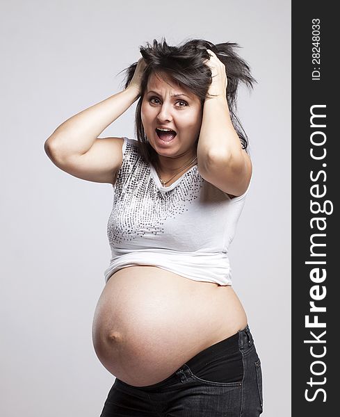 Scared pregnant woman holding her head