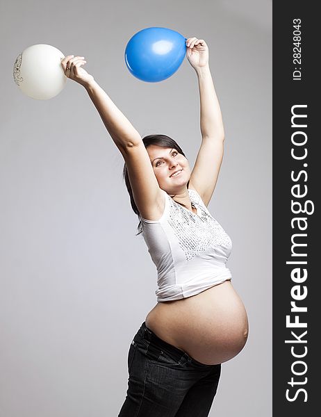 Beautiful pregnant woman playing with balloons