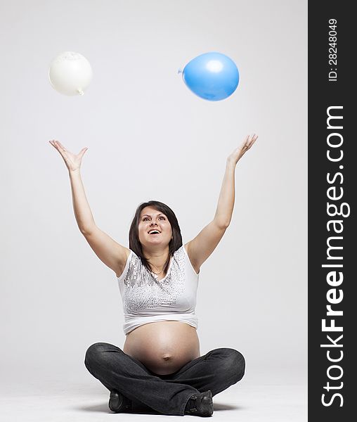 Beautiful pregnant woman playing with balloons