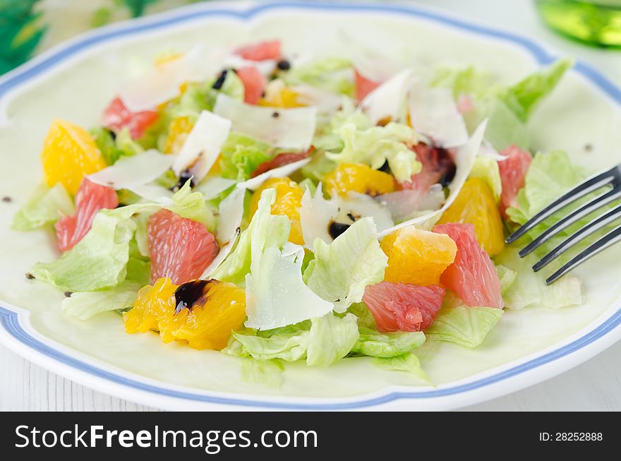 Salad with grapefruit, oranges, iceberg lettuce and grated chees