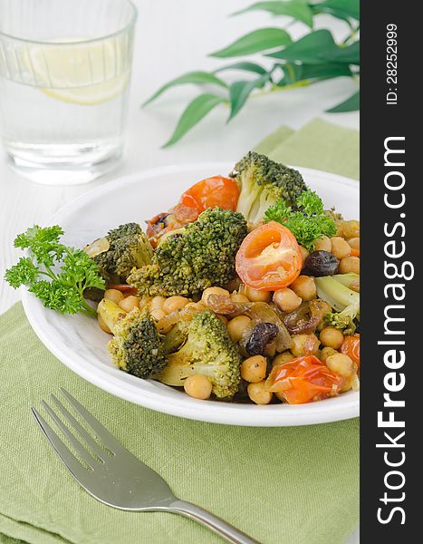 Warm salad with chickpeas, broccoli, raisins, closeup