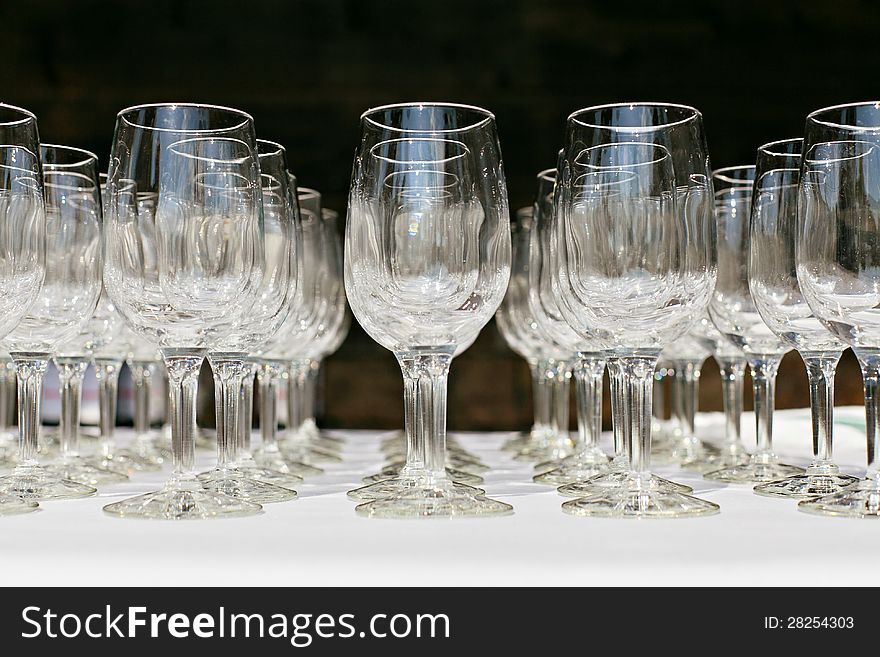 Empty wine glasses set up in a row on the table on black background