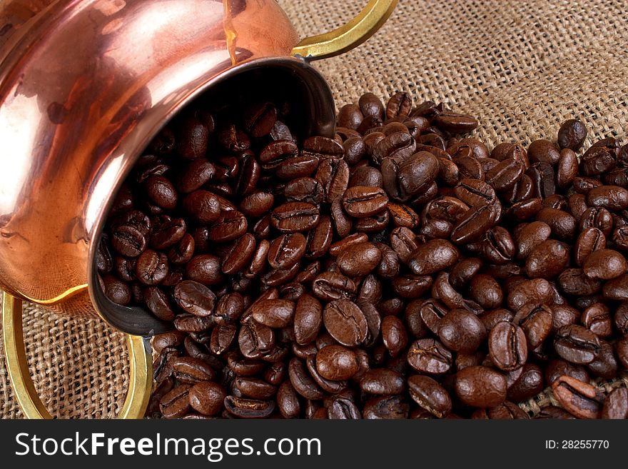 Coffee beans and copper container on burlap. Coffee beans and copper container on burlap